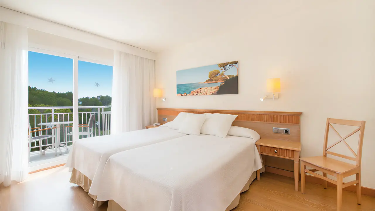 Jasny pokój z łóżkami w Iberostar Waves Club Cala Barca