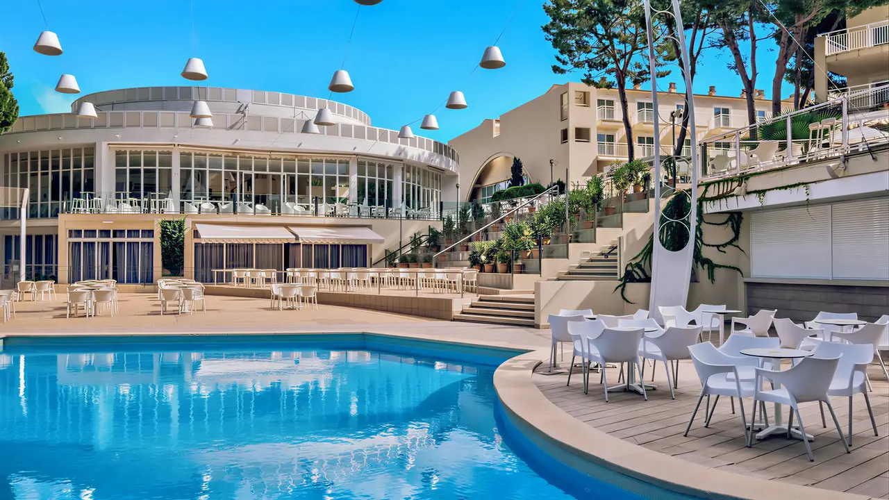 Basen z leżakami i stolikami w Iberostar Waves Club Cala Barca