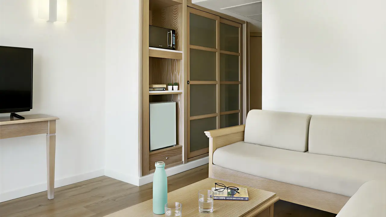 Wnętrze pokoju w Iberostar Waves Club Cala Barca z sofą i stolikiem