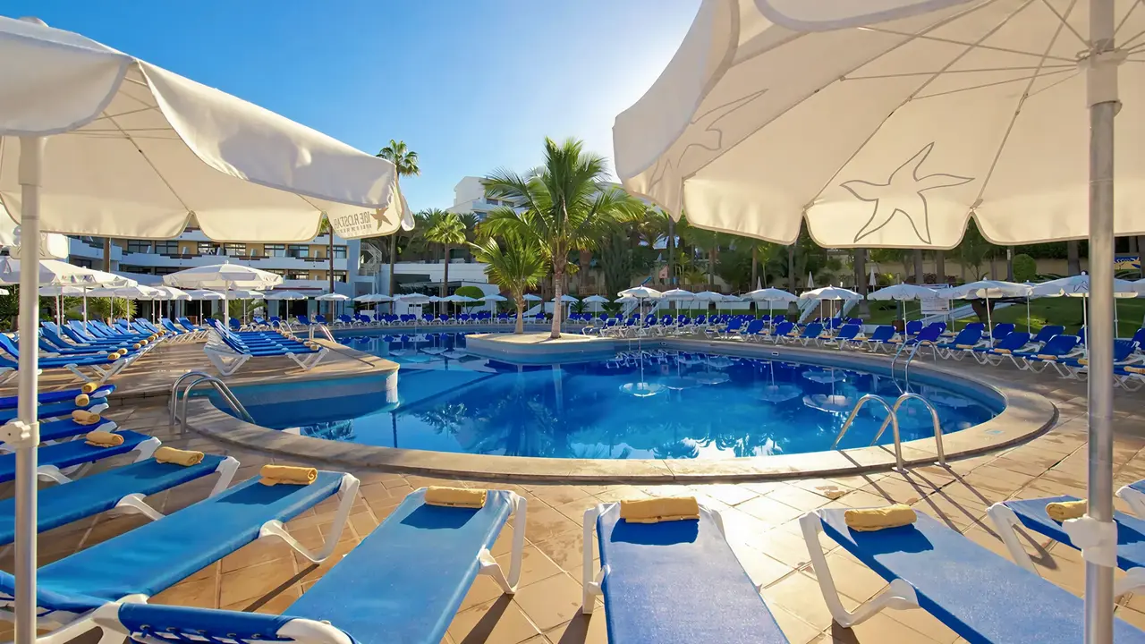 Basen z leżakami i parasolami w Iberostar Waves Las Dalias