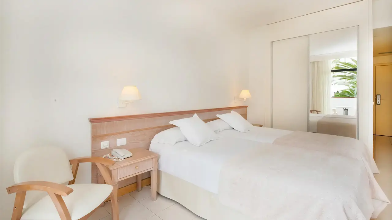 Jasna sypialnia z białym łóżkiem w Iberostar Waves Las Dalias