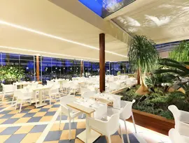 Elegancka restauracja w Iberostar Waves Malaga Playa z białymi stolikami