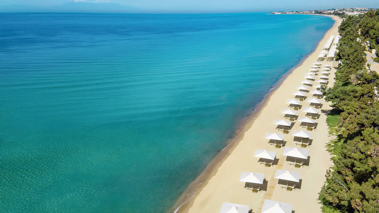 Piaszczysta plaża z parasolami w Ikos Oceania