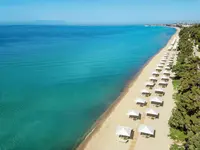 Piaszczysta plaża z parasolami w Ikos Oceania