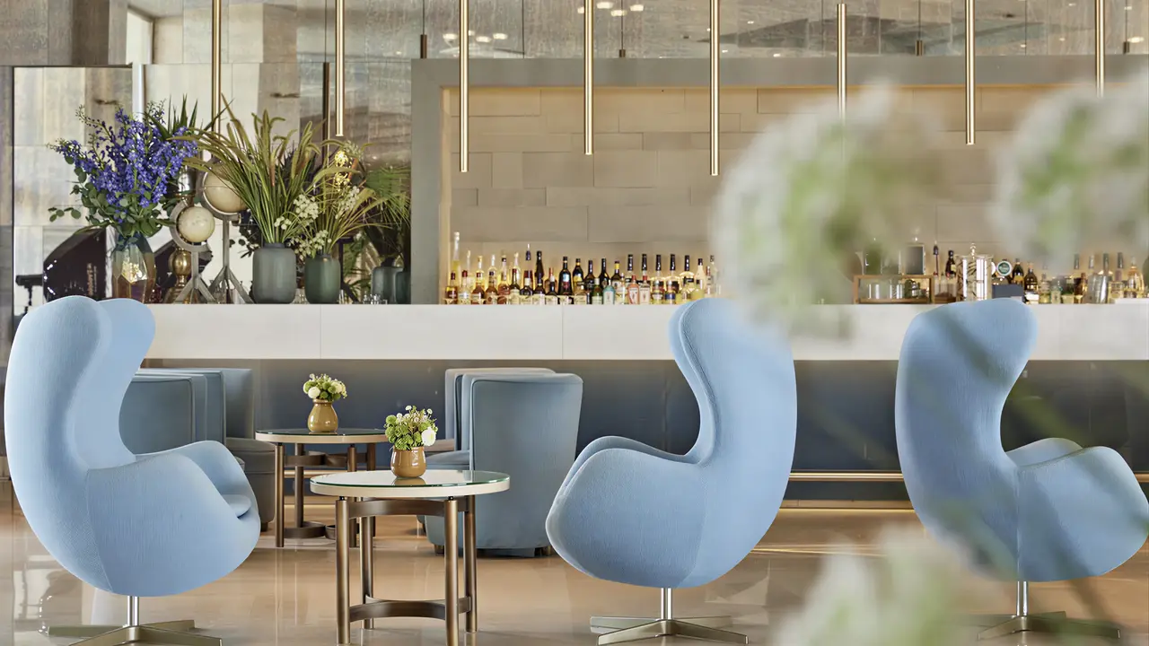 Elegancki bar z niebieskimi fotelami w Ikos Oceania