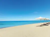 Plaża z leżakami i parasolami w Ikos Oceania