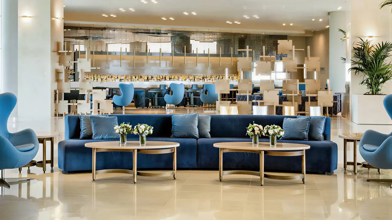 Elegancki lobby w Ikos Oceania z niebieskimi meblami