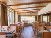 Restauracja w Ionian Sea & Aquapark z drewnianymi stołami i krzesłami