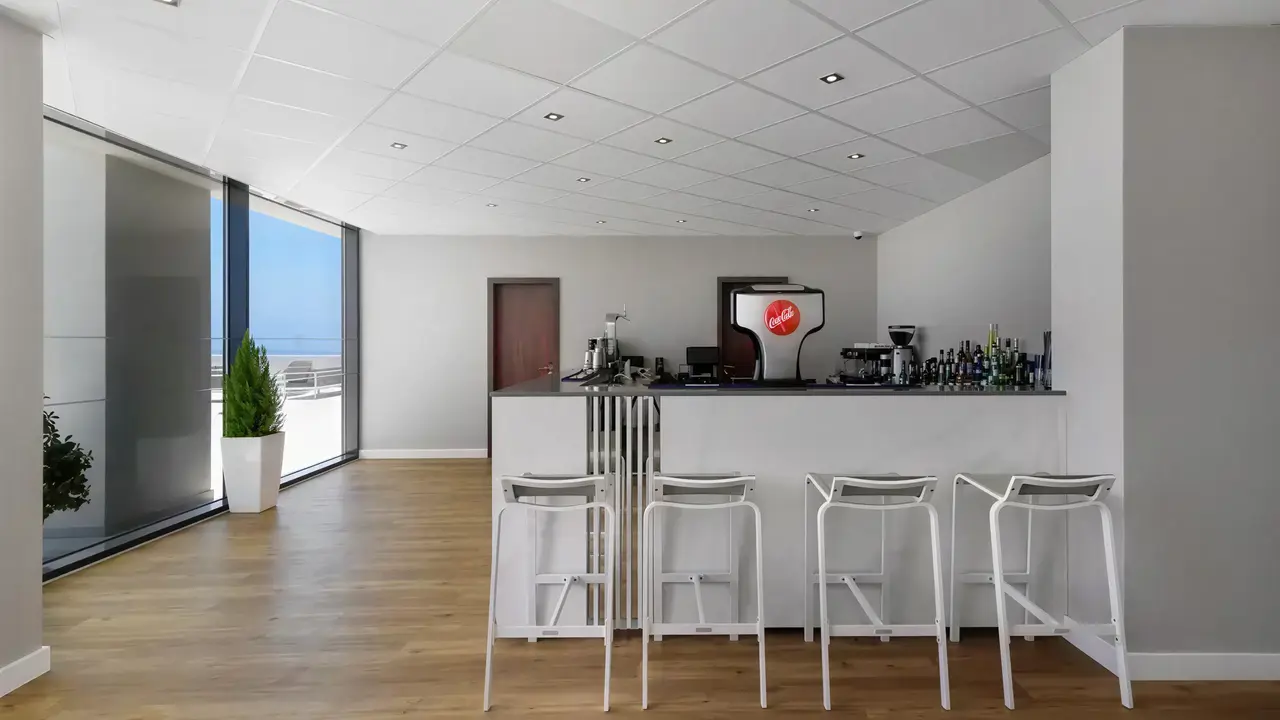 Nowoczesny bar w Jupiter Albufeira z białymi hokerami