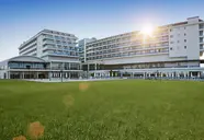 Nowoczesna fasada budynku Kahya Resort Aqua & Spa z zielonym trawnikiem