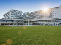 Nowoczesna fasada budynku Kahya Resort Aqua & Spa z zielonym trawnikiem