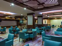 Sala rozrywkowa z niebieskimi fotelami w Kahya Resort Aqua & Spa