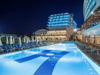 Basen z leżakami w Kahya Resort Aqua & Spa nocą