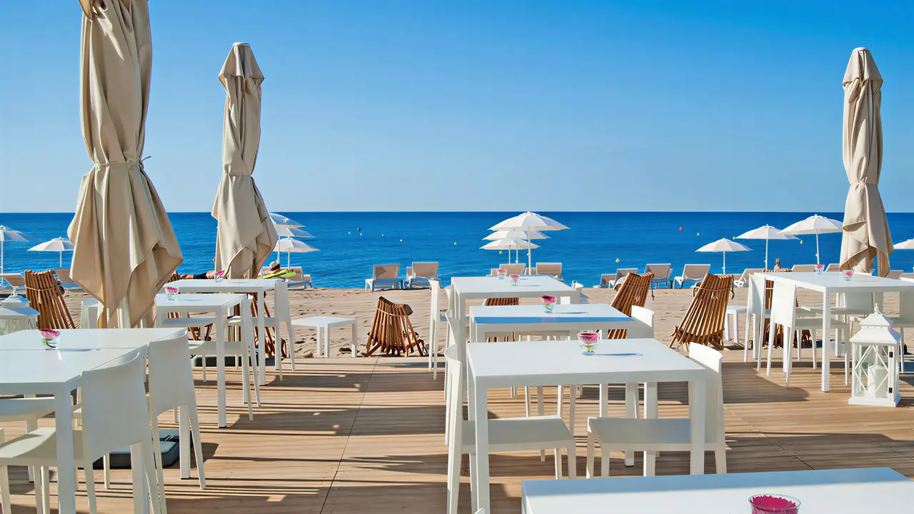Taras z białymi stolikami w Kaktus Playa przy plaży