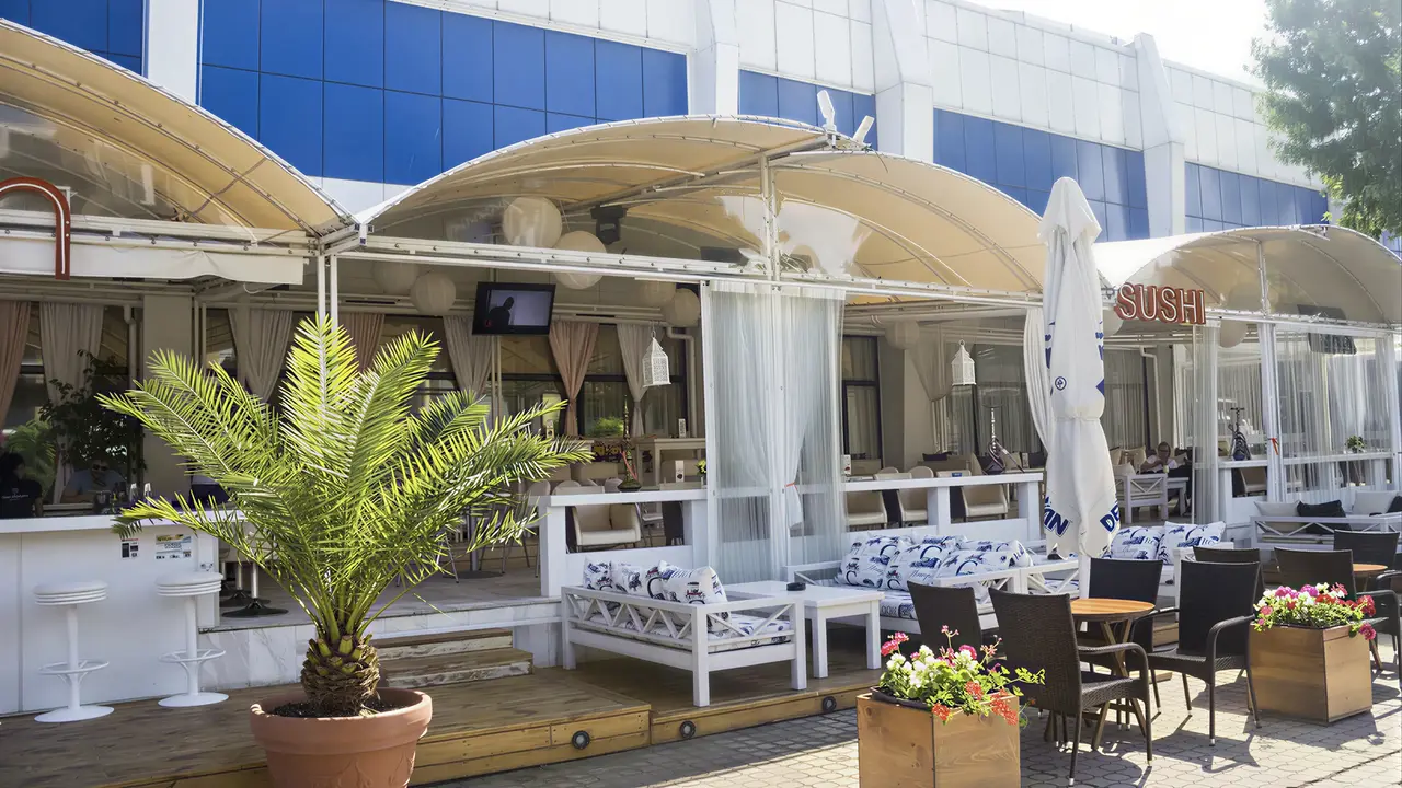 Taras restauracyjny w Kuban Resort & AquaPark z białymi meblami