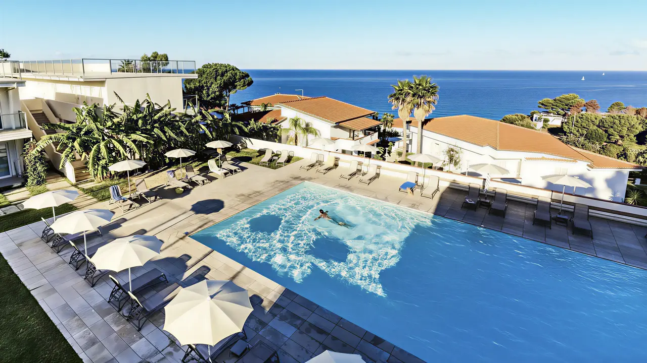Basen z leżakami i parasolami w La Conchiglia Suites & Spa