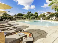 Basen z leżakami i parasolami w La Conchiglia Suites & Spa