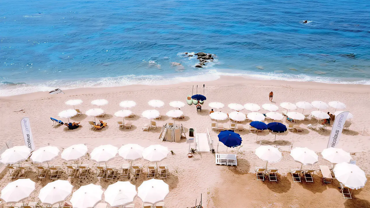 Plaża z parasolami i leżakami w La Conchiglia Suites & Spa