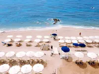 Plaża z parasolami i leżakami w La Conchiglia Suites & Spa
