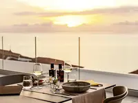 Nakryty stół z winem w La Conchiglia Suites & Spa o zachodzie