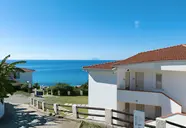 Białe budynki La Conchiglia Suites & Spa nad brzegiem morza