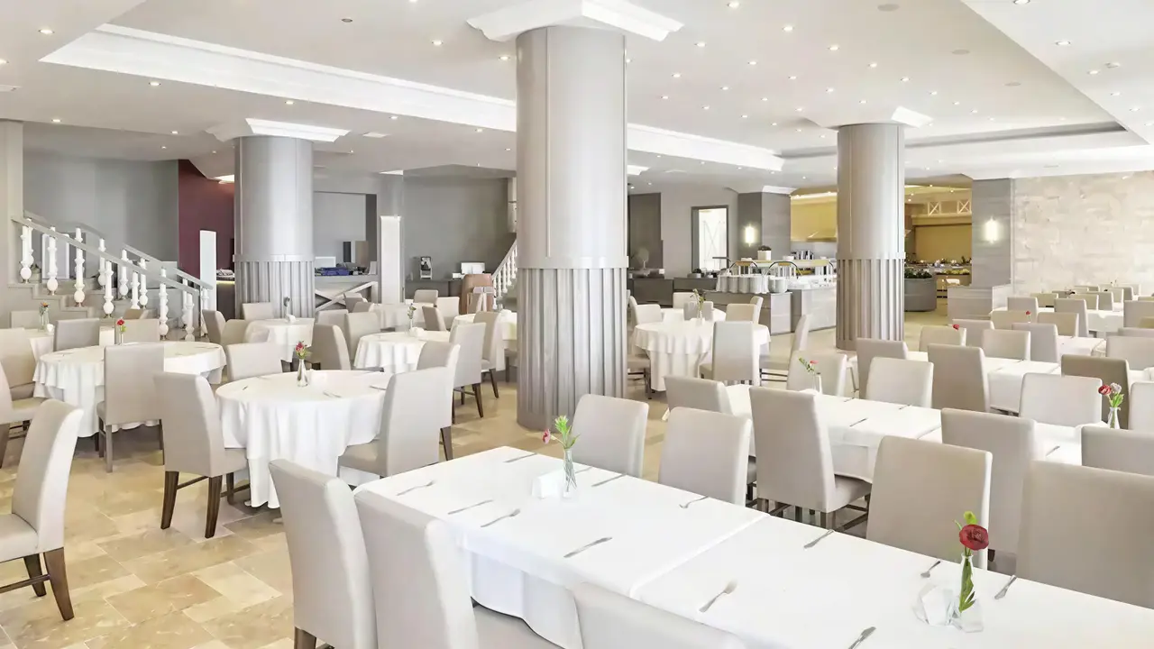 Jasna restauracja w Ladonia Hotels Adakule z białymi stołami