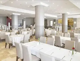 Jasna restauracja w Ladonia Hotels Adakule z białymi stołami