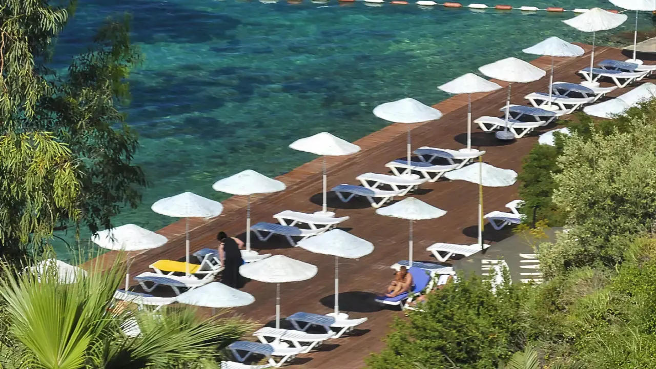 Leżaki i parasole przy plaży w Ladonia Hotels Adakule