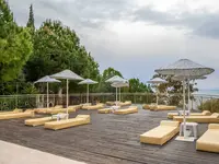 Taras z leżakami i parasolami w Ladonia Hotels Adakule