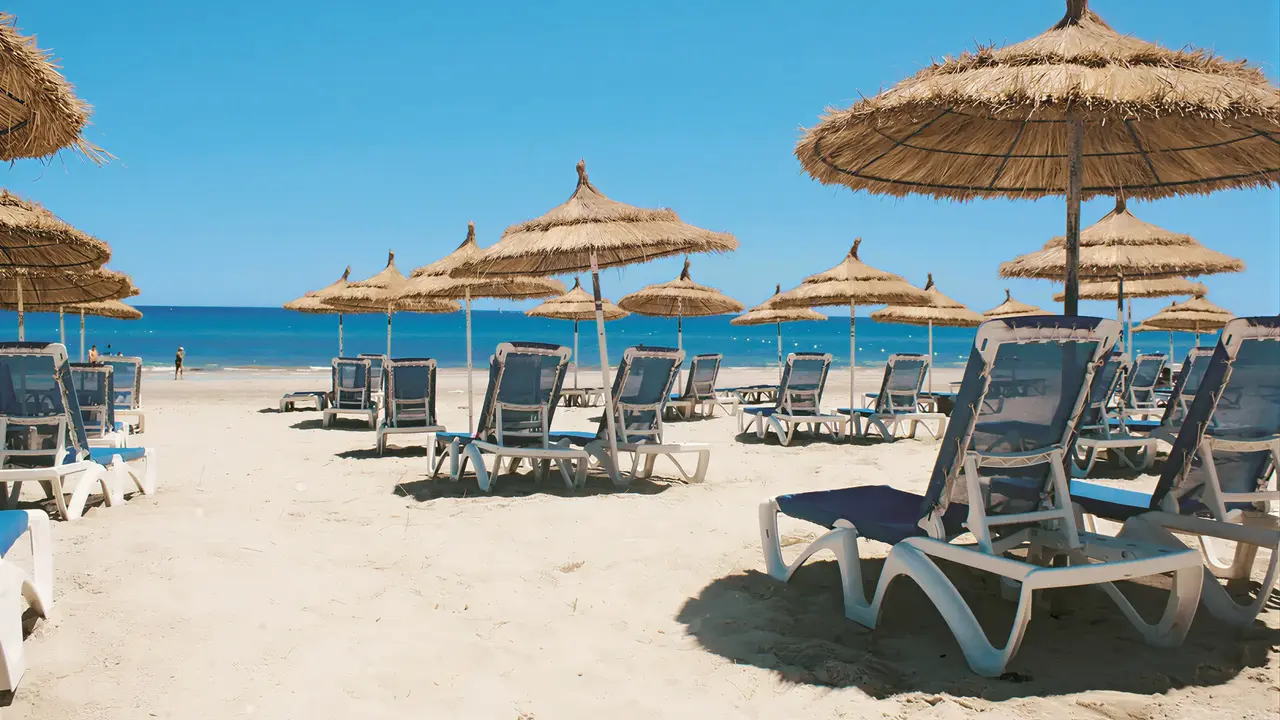 Plaża z leżakami i parasolami w Les Quatres Saisons by Medina