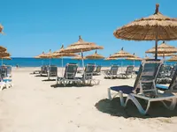 Plaża z leżakami i parasolami w Les Quatres Saisons by Medina