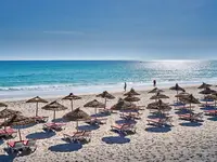 Plaża z leżakami i parasolami w Les Quatres Saisons by Medina