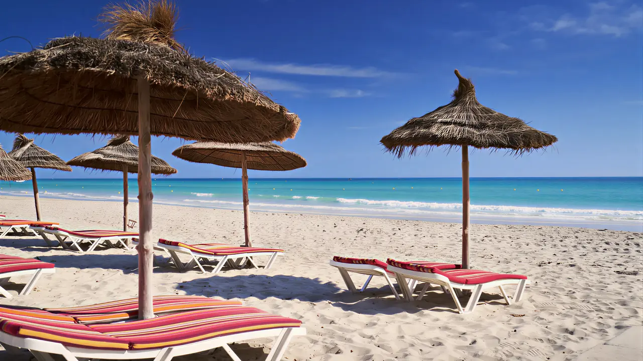 Leżaki i parasole na plaży w Les Quatres Saisons by Medina