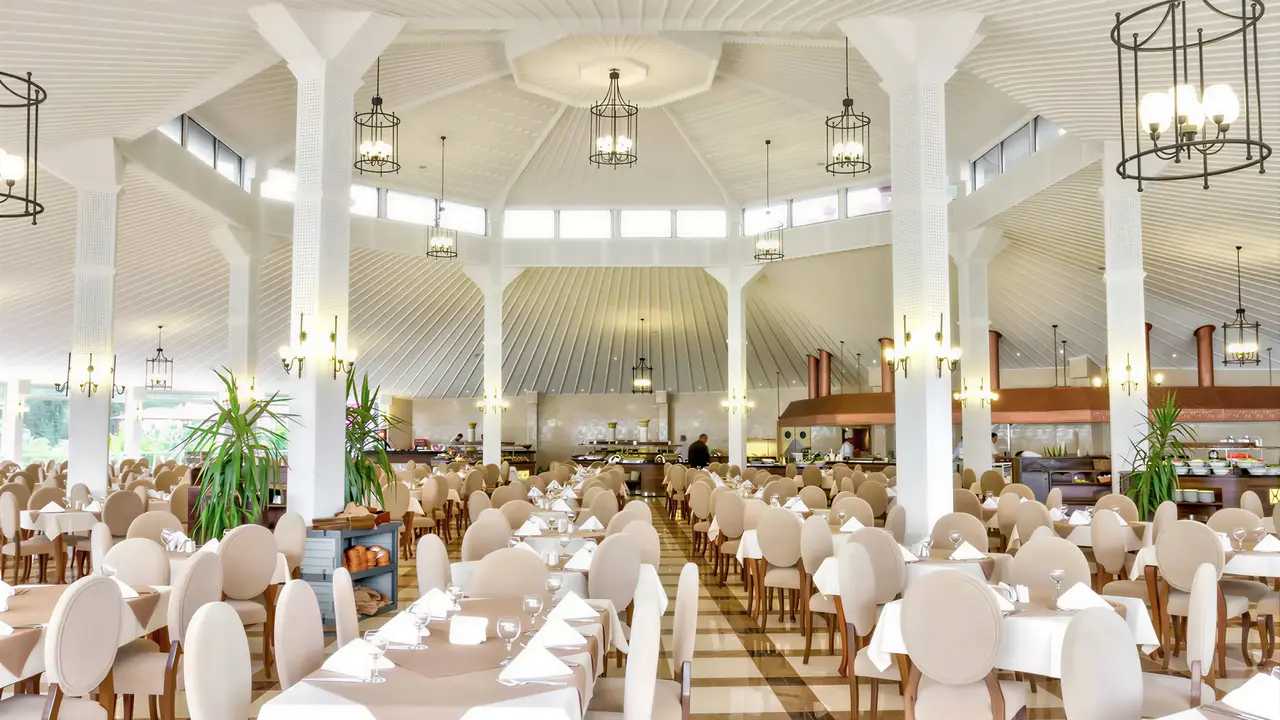 Jasna restauracja z białymi stołami w Letoonia Club