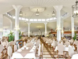 Jasna restauracja z białymi stołami w Letoonia Club