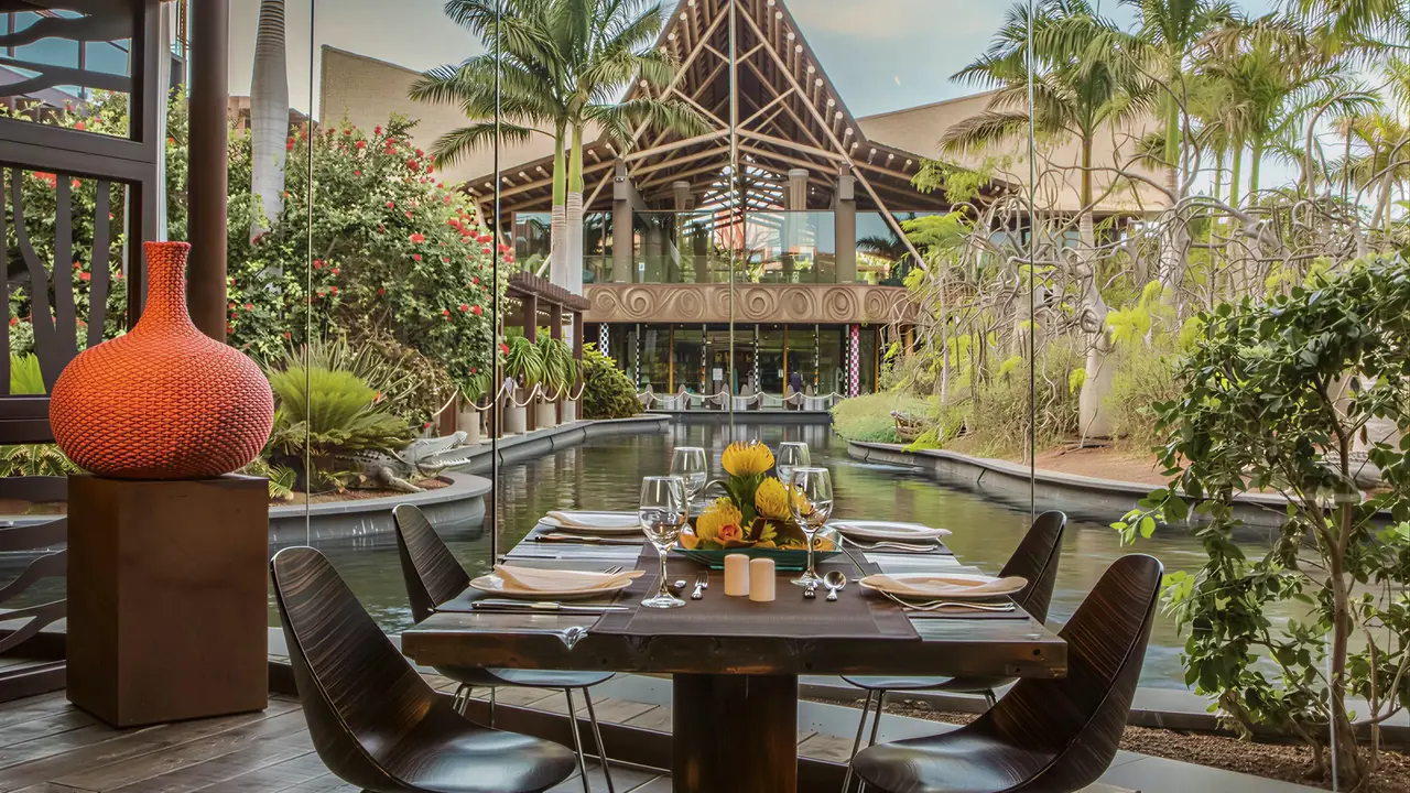 Stół w restauracji Lopesan Baobab Resort z widokiem na ogród