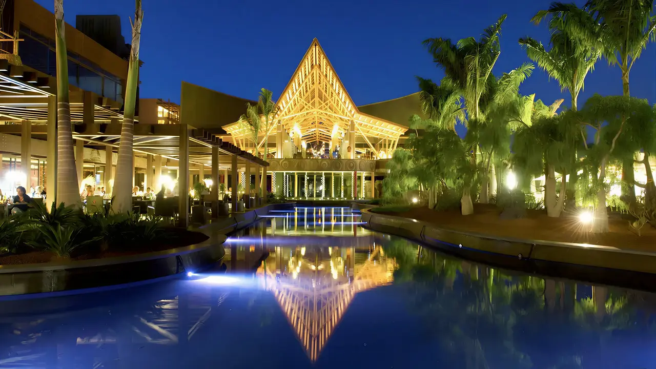Elewacja i oświetlony basen w Lopesan Baobab Resort nocą