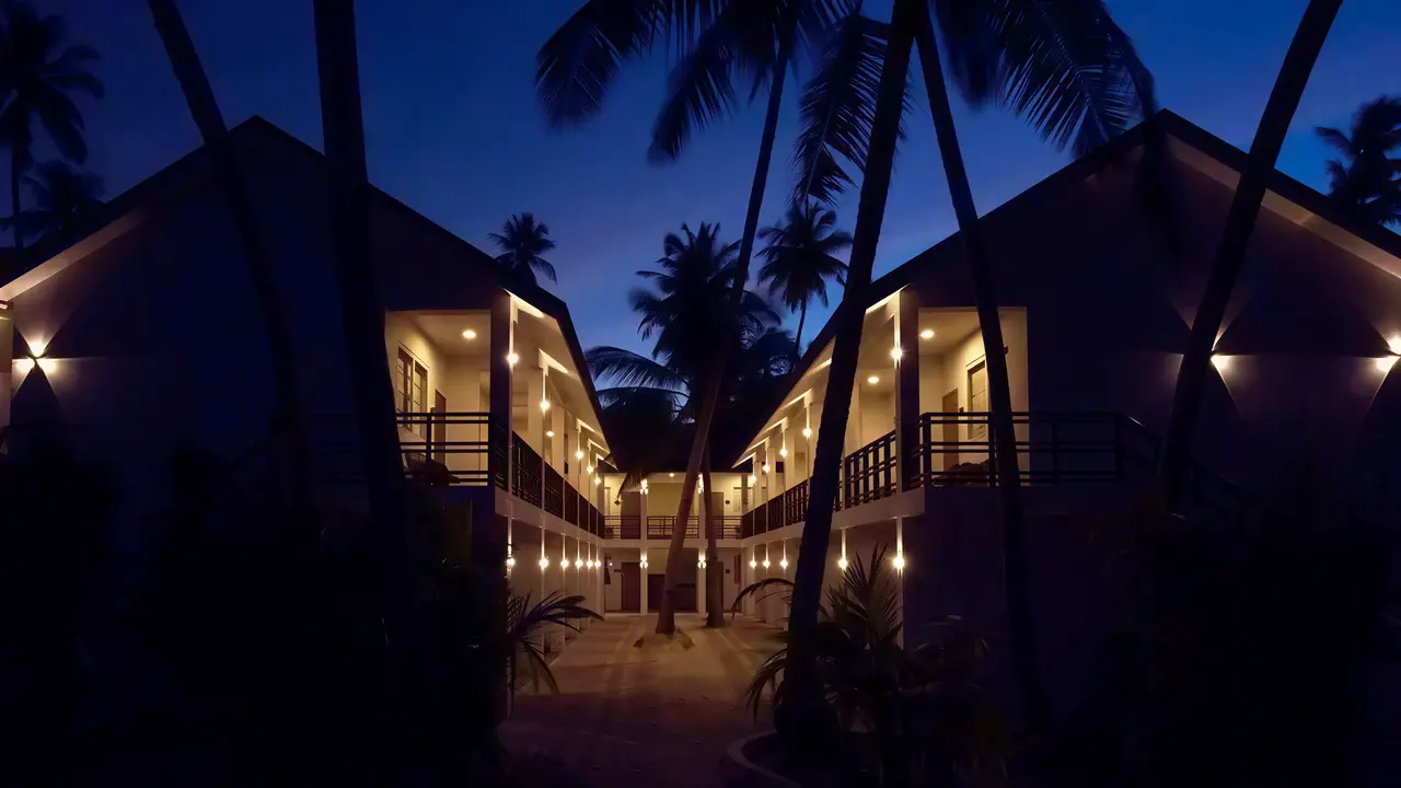 Budynki Malahini Kuda Bandos nocą wśród palm