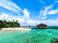 Biała plaża i turkusowa woda w Medhufushi Island Resort