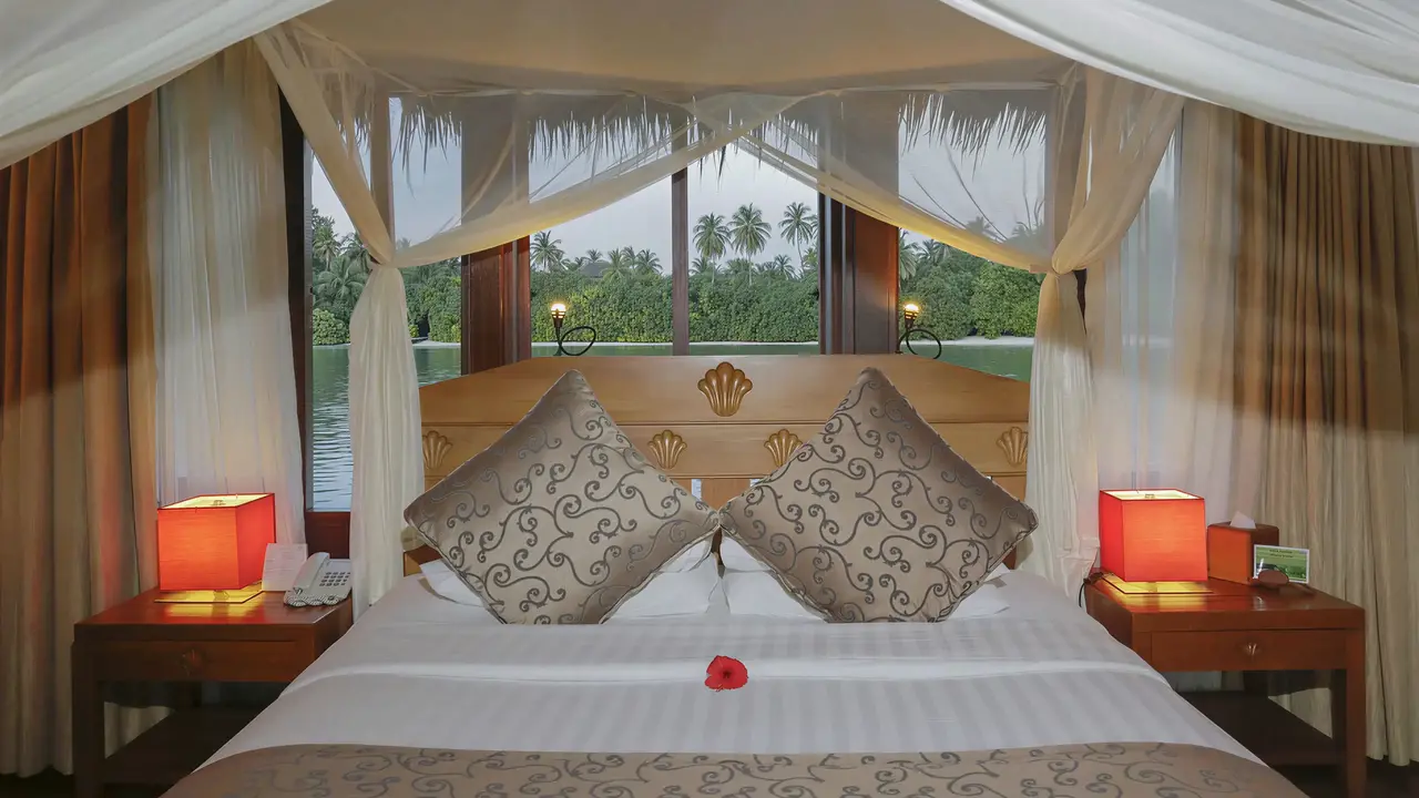 Przytulna sypialnia z łóżkiem w Medhufushi Island Resort