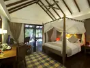 Sypialnia z łóżkiem z baldachimem w Medhufushi Island Resort