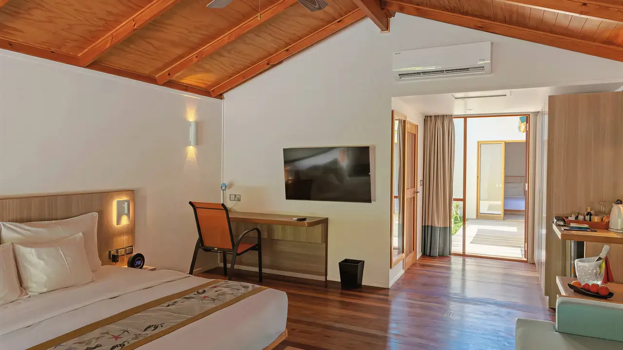 Wnętrze sypialni w Meeru Island Resort z drewnianym sufitem