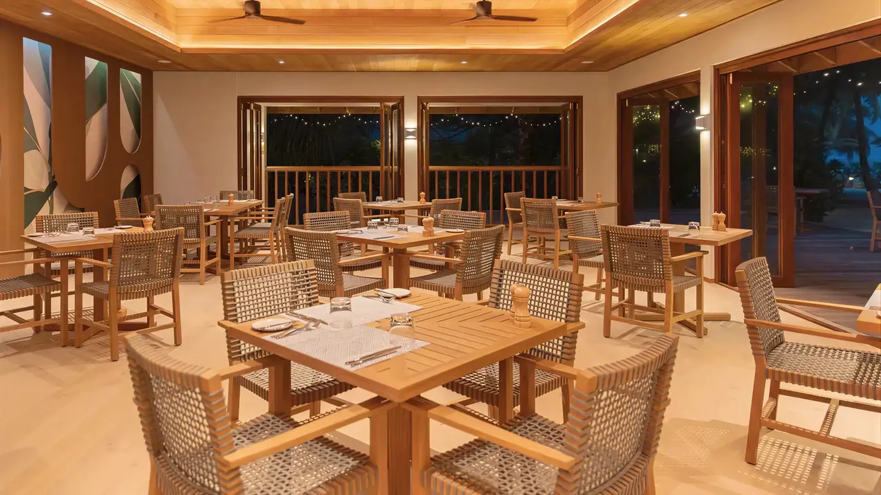 Restauracja w Meeru Island Resort z drewnianymi stołami