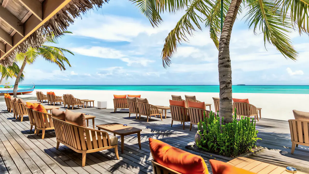 Drewniany taras z leżakami w Meeru Island Resort przy plaży