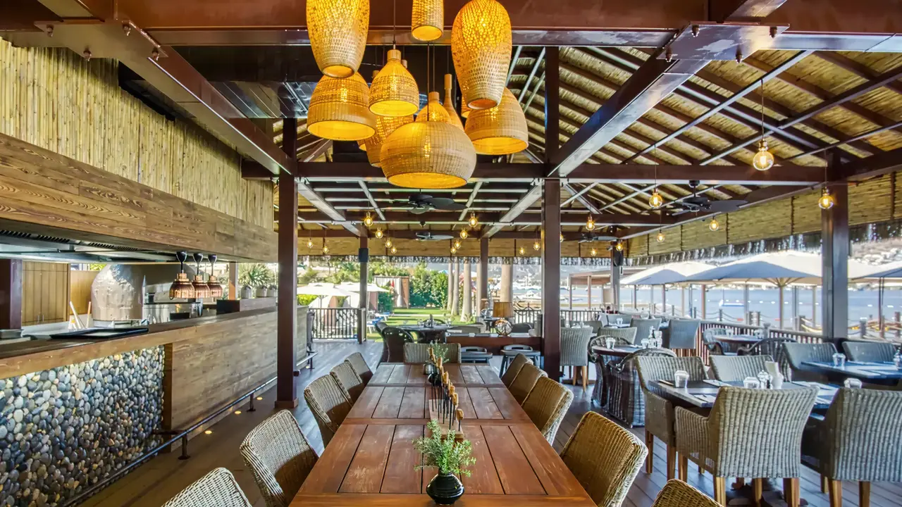 Restauracja w Mivara Luxury Resort & Spa Bodrum z drewnianymi stołami