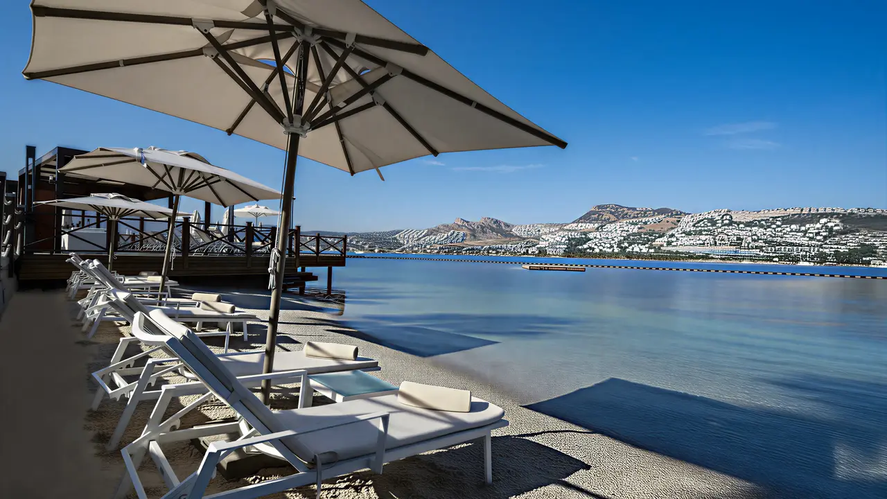 Leżaki i parasole na plaży w Mivara Luxury Resort & Spa Bodrum