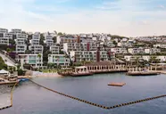 Widok na kompleks budynków Mivara Luxury Resort & Spa Bodrum nad wodą