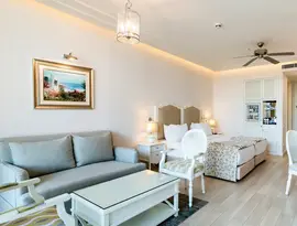 Jasny pokój z łóżkami i sofą w Mivara Luxury Resort & Spa Bodrum