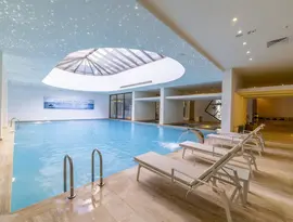 Kryty basen z leżakami w Mivara Luxury Resort & Spa Bodrum