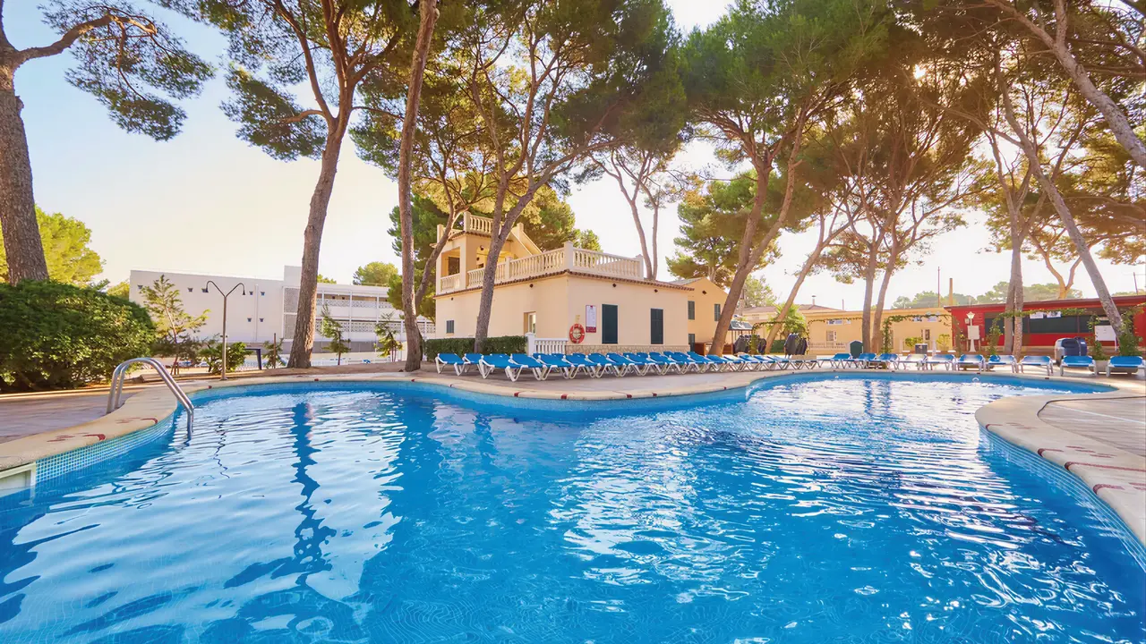 Basen zewnętrzny w MLL Palma Bay Club Resort wśród wysokich drzew